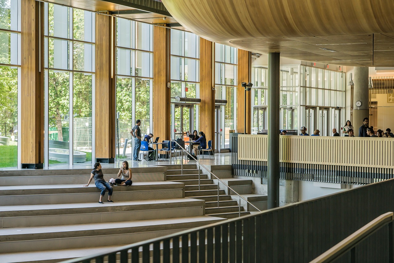 Students sitting on the stairs of a university offering a scokiolgy degree