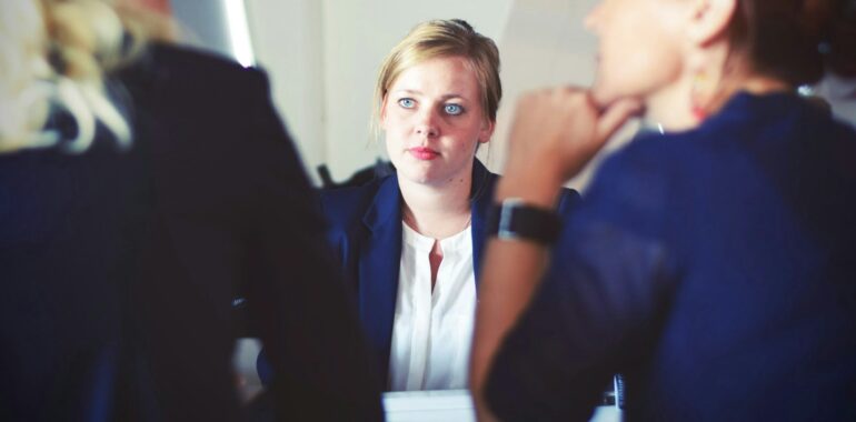 A woman sitting in a workplace offering different sociology degree jobs