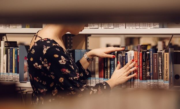 A student checking books in a library.