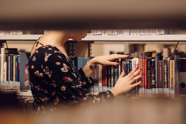 A student checking books in a library.